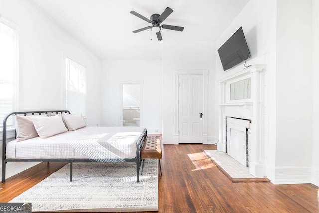 bedroom featuring hardwood / wood-style flooring, ensuite bathroom, and ceiling fan