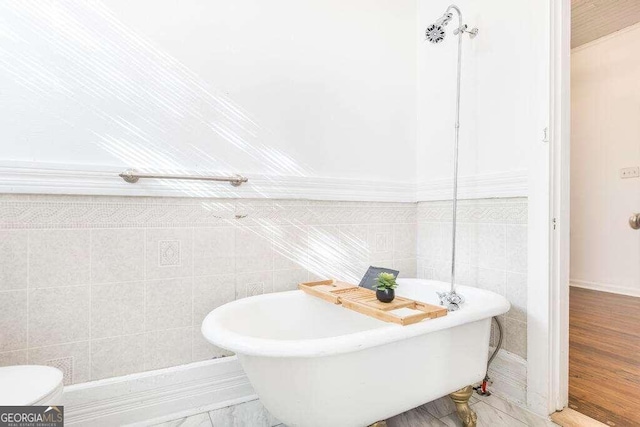 bathroom featuring tile walls and a tub