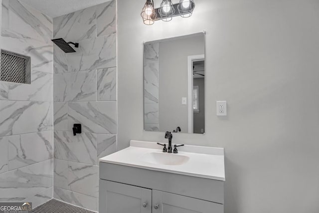 bathroom with vanity and a tile shower