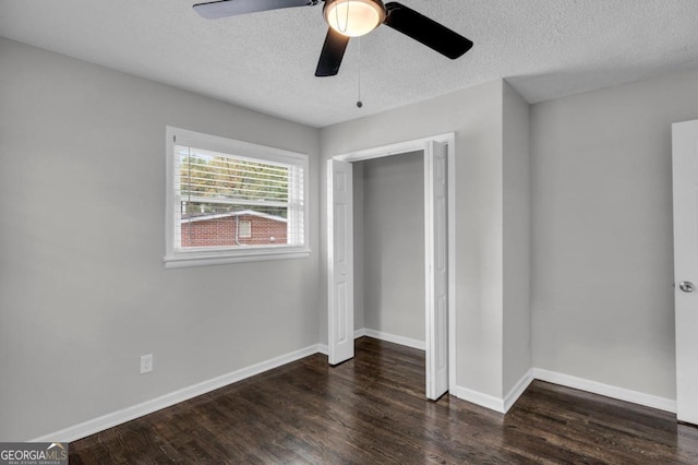 unfurnished bedroom featuring ceiling fan, dark hardwood / wood-style floors, a textured ceiling, and a closet