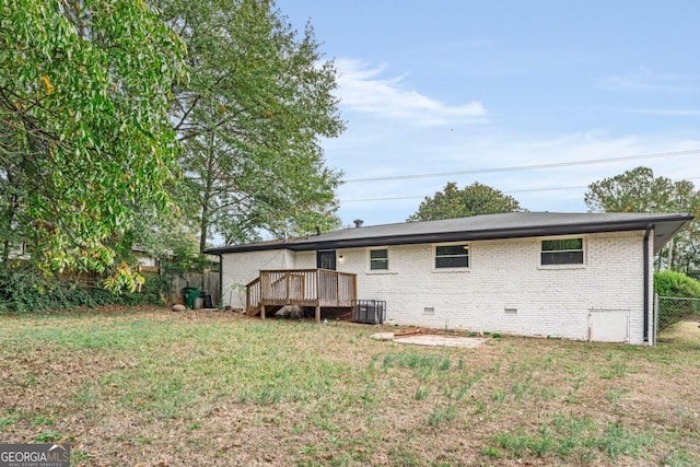 rear view of house with cooling unit, a lawn, and a deck