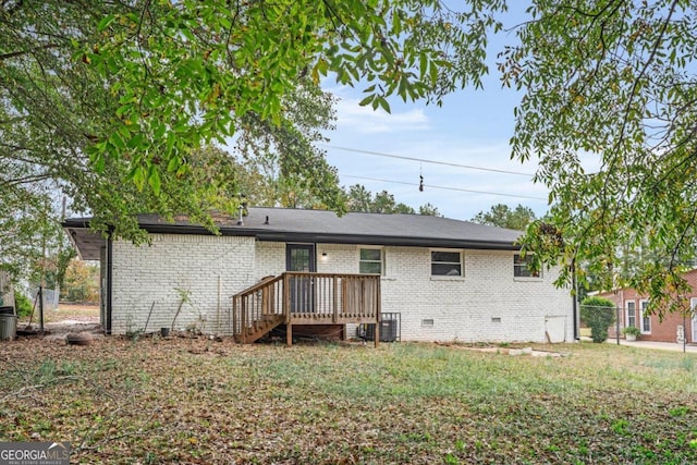 back of property with a deck and a lawn