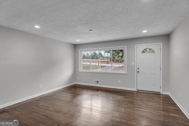 entryway with dark hardwood / wood-style floors and a textured ceiling