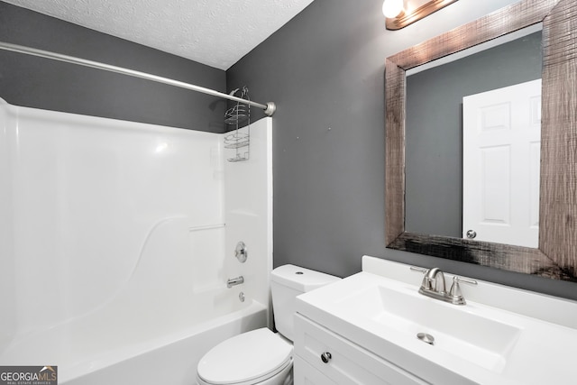 full bathroom with washtub / shower combination, vanity, a textured ceiling, and toilet