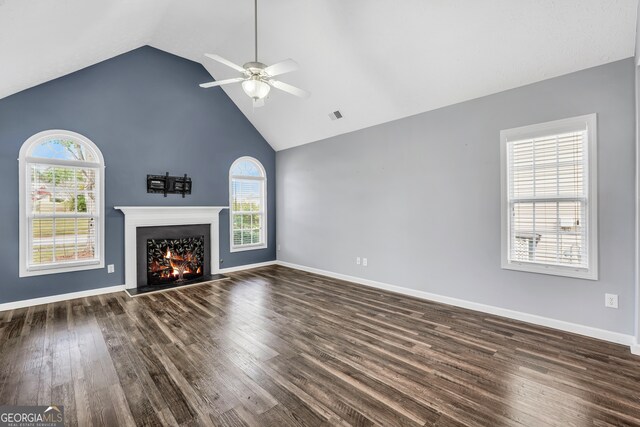 unfurnished living room featuring dark hardwood / wood-style floors, high vaulted ceiling, a wealth of natural light, and ceiling fan