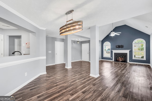 unfurnished living room with lofted ceiling, ceiling fan with notable chandelier, crown molding, a textured ceiling, and dark hardwood / wood-style flooring