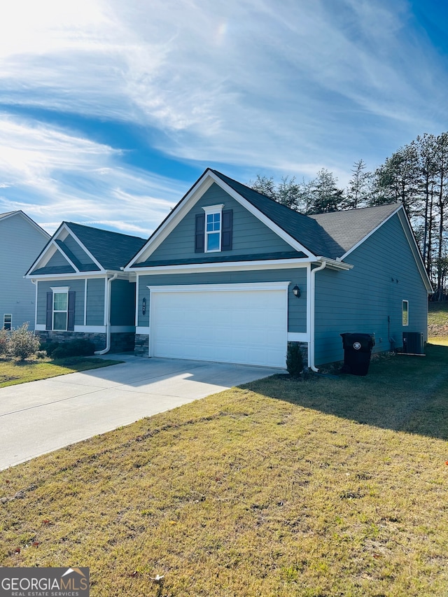 ranch-style house featuring central AC unit, a front yard, and a garage