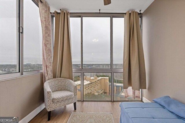 sitting room with ceiling fan, plenty of natural light, and light wood-type flooring