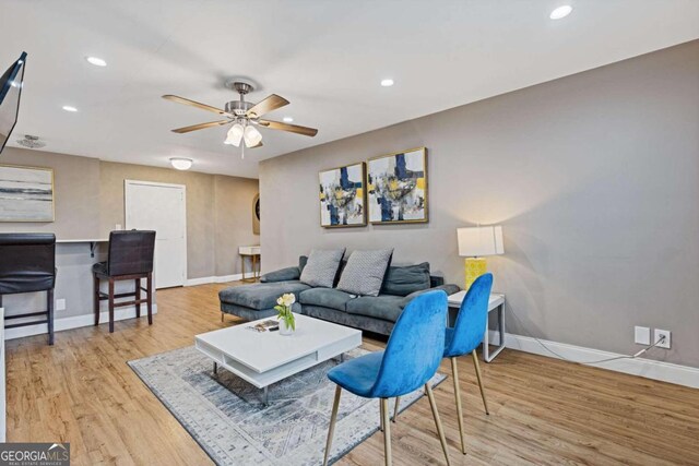 living room featuring ceiling fan and light hardwood / wood-style flooring