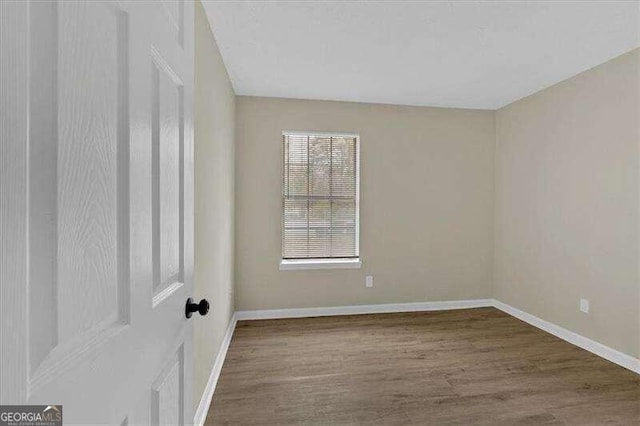 empty room with dark hardwood / wood-style flooring