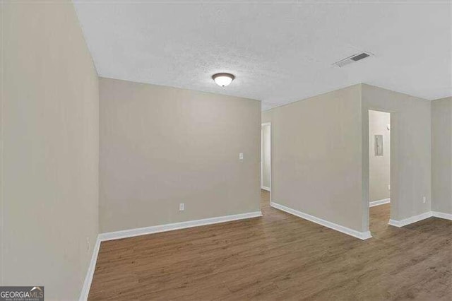 unfurnished room with dark hardwood / wood-style floors and a textured ceiling