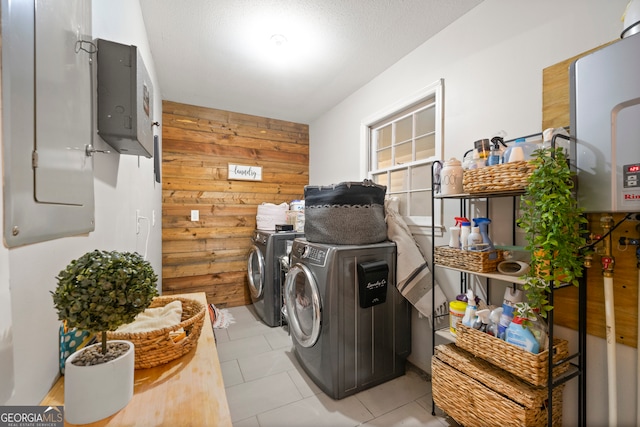 laundry area with electric panel, separate washer and dryer, tankless water heater, and wood walls