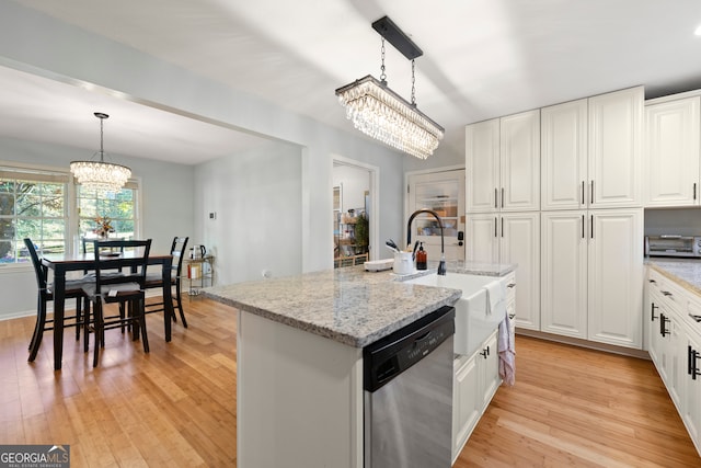 kitchen featuring stainless steel dishwasher, pendant lighting, a center island with sink, and light wood-type flooring