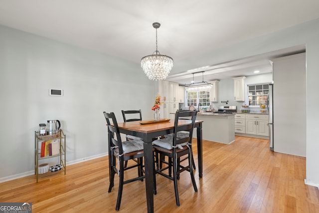 dining room with a notable chandelier and light wood-type flooring