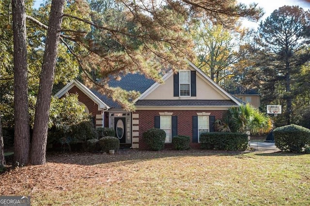 traditional home with brick siding, a front lawn, and roof with shingles