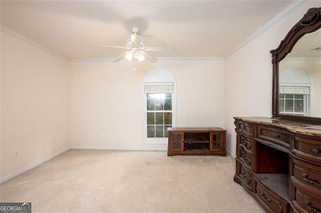 interior space with light carpet, ceiling fan, ornamental molding, and baseboards