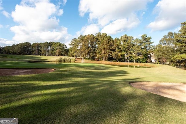 view of home's community with view of golf course and a yard