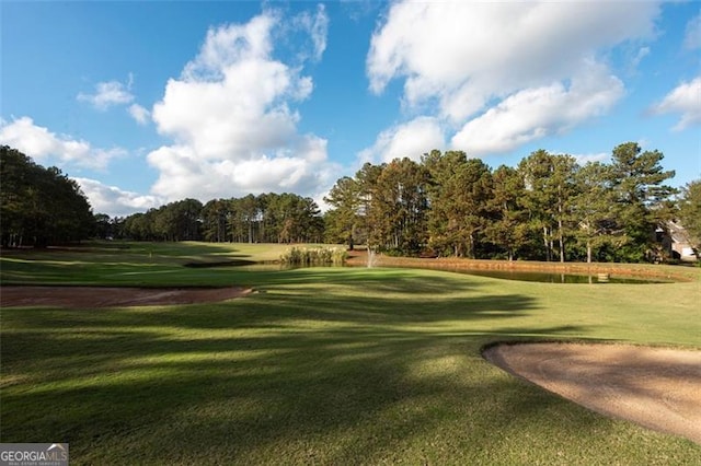 view of home's community featuring view of golf course and a lawn