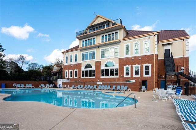 community pool with a patio and fence