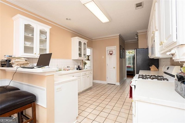 kitchen with visible vents, white cabinets, a breakfast bar area, a peninsula, and light tile patterned flooring