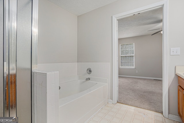 bathroom with vanity, ceiling fan, a textured ceiling, and a washtub