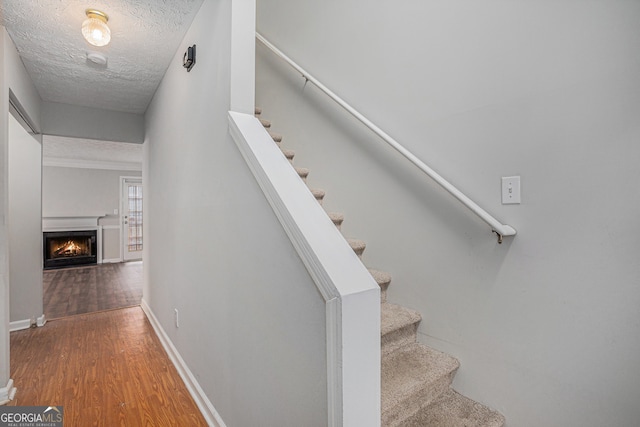 stairway featuring hardwood / wood-style floors and a textured ceiling