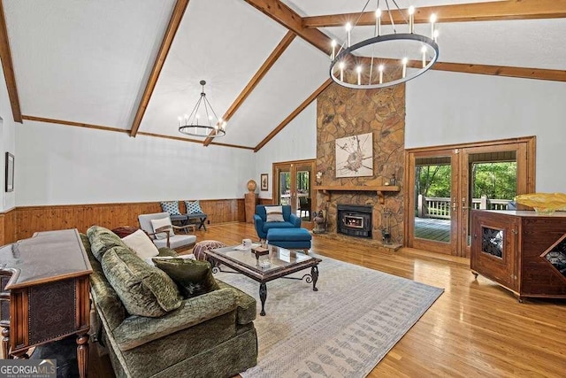 living room with wood walls, high vaulted ceiling, light wood-type flooring, beamed ceiling, and a notable chandelier