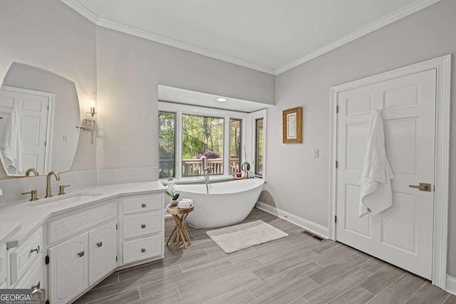 bathroom with a bath, hardwood / wood-style floors, vanity, and crown molding