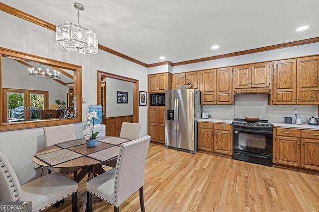 kitchen featuring stainless steel fridge, ornamental molding, black range with electric cooktop, pendant lighting, and light hardwood / wood-style flooring