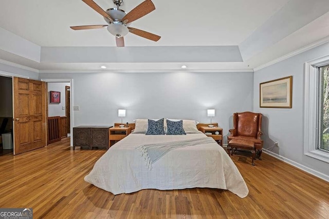 bedroom featuring multiple windows, ceiling fan, and hardwood / wood-style flooring