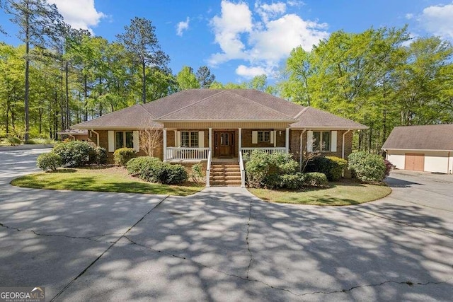 single story home with a porch and an outdoor structure