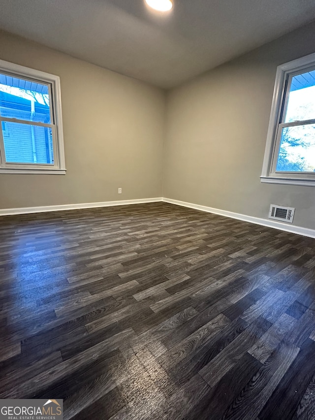 unfurnished room featuring dark wood-type flooring