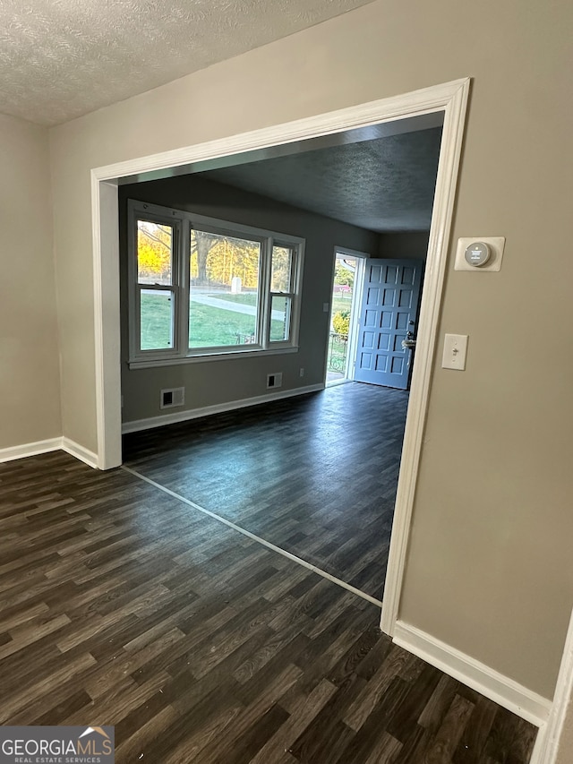 interior space featuring a textured ceiling and dark hardwood / wood-style floors