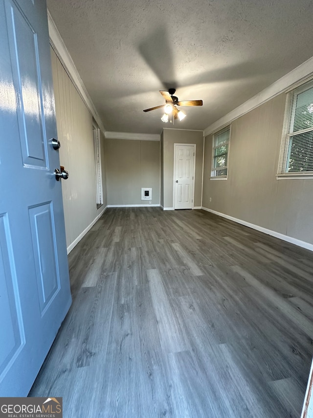 empty room featuring hardwood / wood-style flooring, ceiling fan, ornamental molding, and a textured ceiling