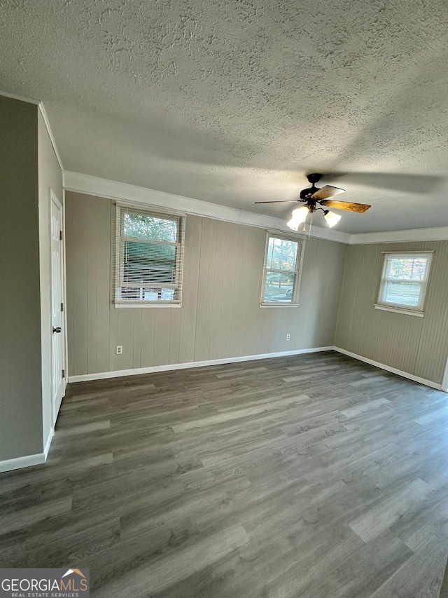 spare room featuring ceiling fan, wood-type flooring, and a textured ceiling