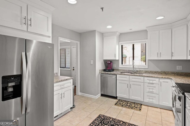 kitchen with light stone countertops, white cabinetry, sink, stainless steel appliances, and light tile patterned flooring