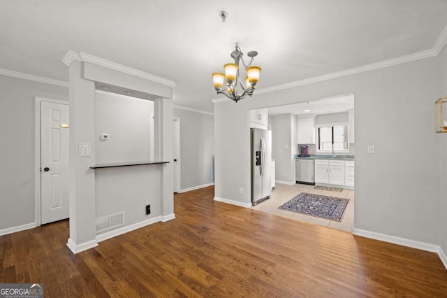 unfurnished dining area featuring hardwood / wood-style flooring, a notable chandelier, and crown molding