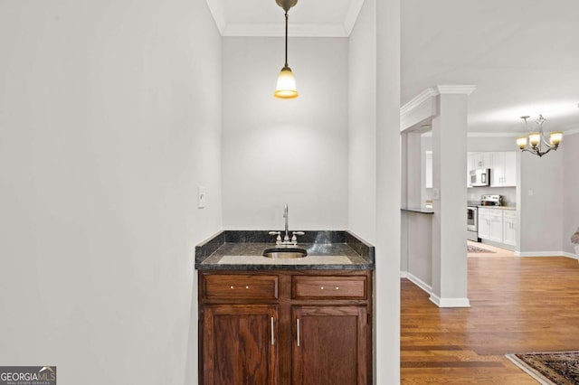 bathroom with hardwood / wood-style floors, crown molding, and sink