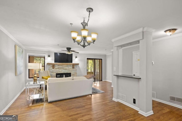 living room with hardwood / wood-style floors, ornamental molding, and a fireplace