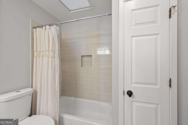 bathroom with a textured ceiling, shower / bath combo, and toilet