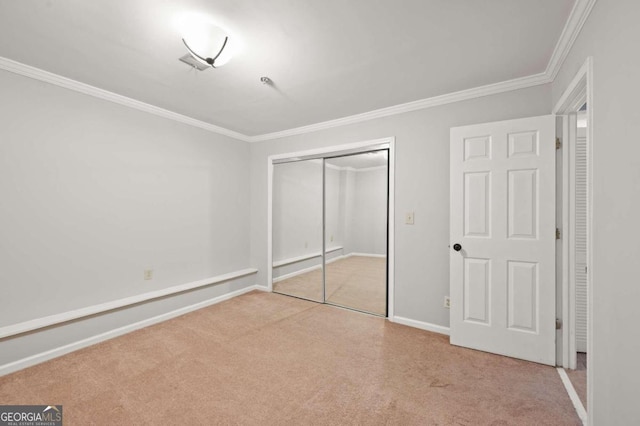 unfurnished bedroom featuring light colored carpet, crown molding, and a closet