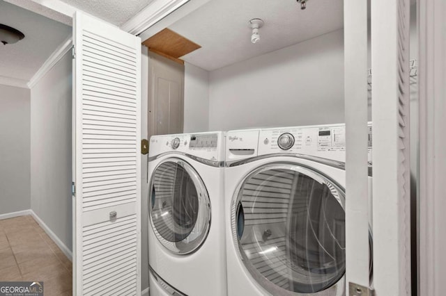 washroom featuring a textured ceiling, separate washer and dryer, crown molding, and light tile patterned flooring