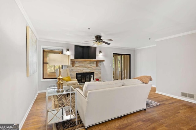 living room with a fireplace, hardwood / wood-style floors, ceiling fan, and ornamental molding