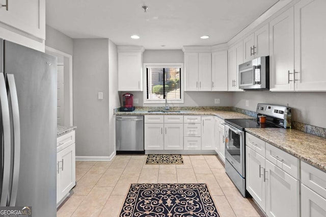 kitchen featuring light stone countertops, white cabinets, and appliances with stainless steel finishes