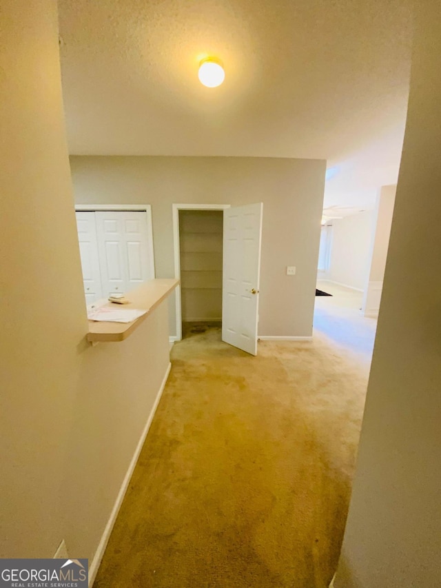 hallway featuring carpet and a textured ceiling