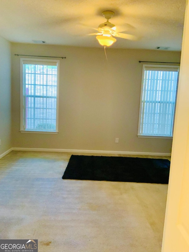 carpeted spare room with ceiling fan