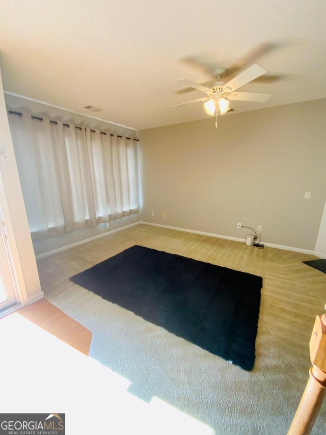 spare room with carpet flooring, ceiling fan, and a healthy amount of sunlight