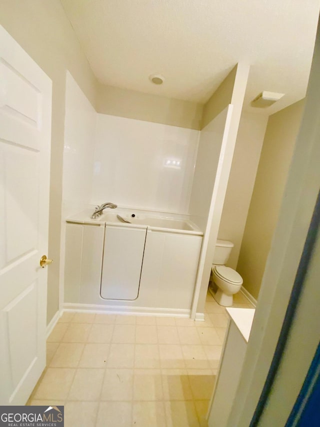 bathroom with tile patterned flooring and toilet