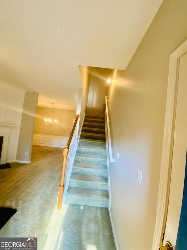 staircase featuring carpet flooring and an inviting chandelier