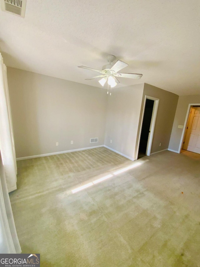 unfurnished room with ceiling fan and light carpet